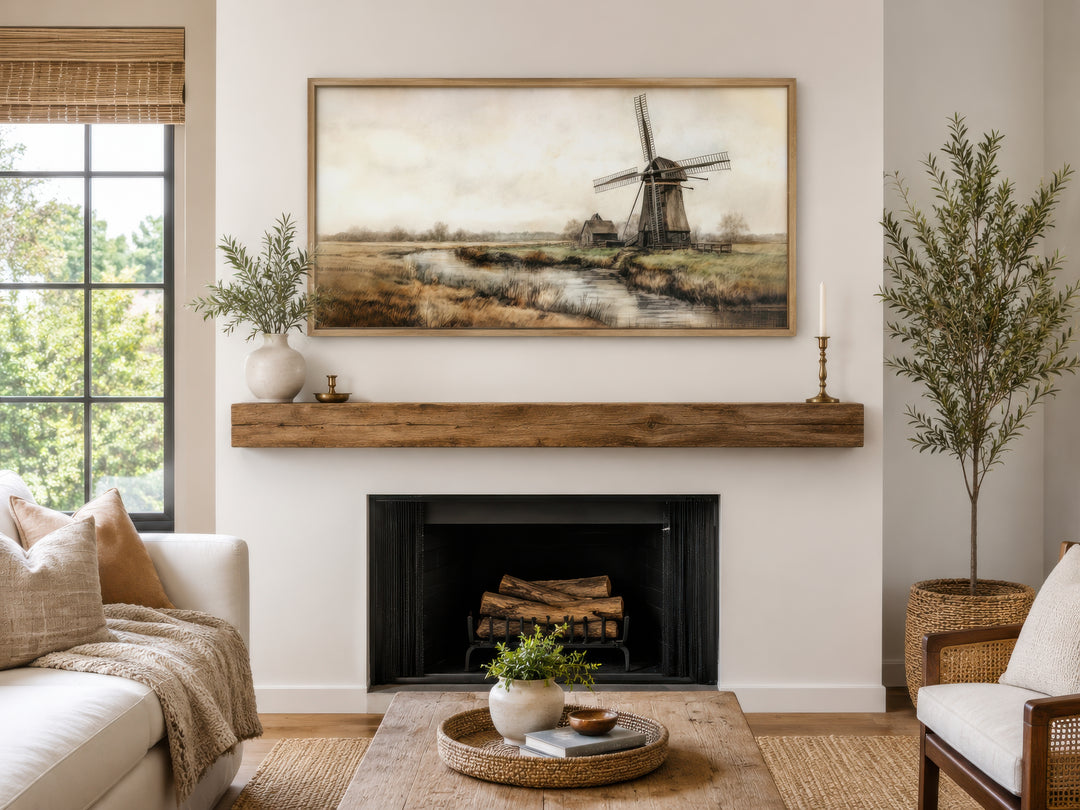 Vintage windmill canvas print in a wooden frame hanging above a rustic fireplace mantel.