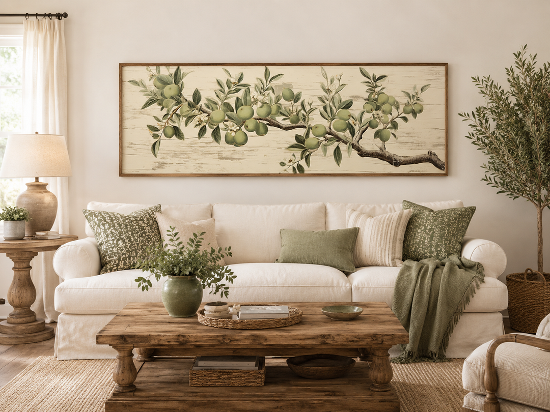 Vintage apple tree branch horizontal framed canvas wall art above a white sofa in a living room.