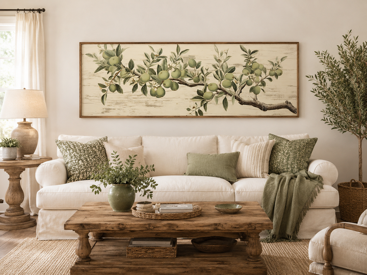 Vintage apple tree branch horizontal framed canvas wall art above a white sofa in a living room.