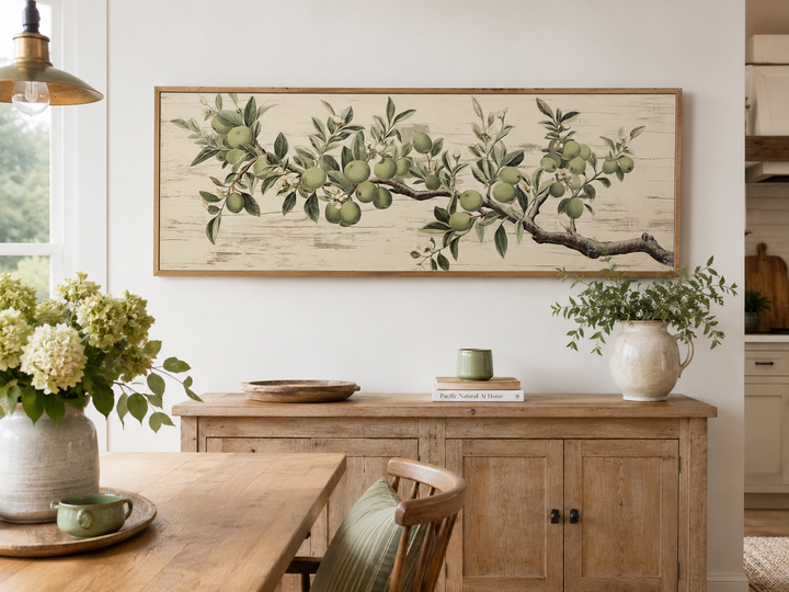 Vintage apple tree branch horizontal framed canvas wall art above a wooden sideboard.