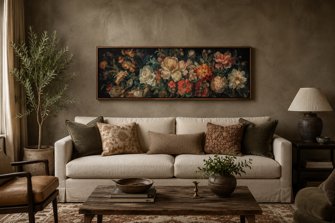 Long horizontal antique style moody floral framed canvas wall art hanging above a cream sofa.