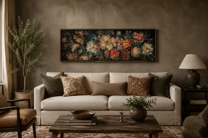 Long horizontal antique style moody floral framed canvas wall art hanging above a cream sofa.