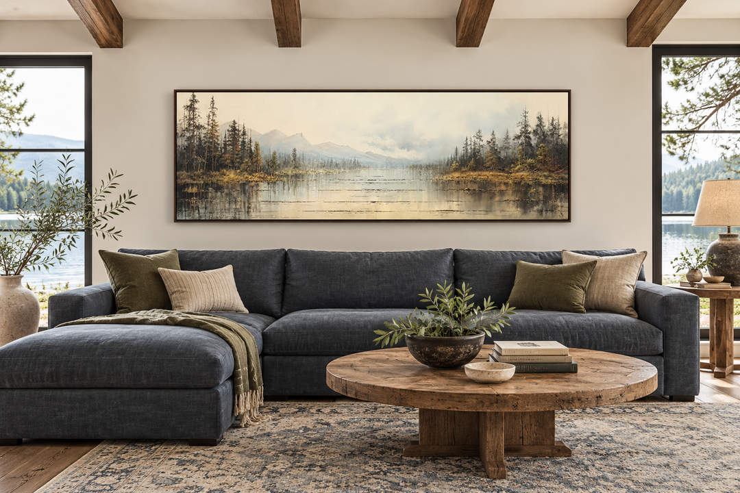 Vintage neutral lake landscape horizontal wall art in a walnut frame above a blue sectional sofa.