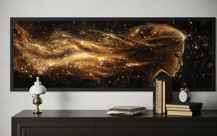Black and gold celestial canvas art with a woman's profile and flowing hair.