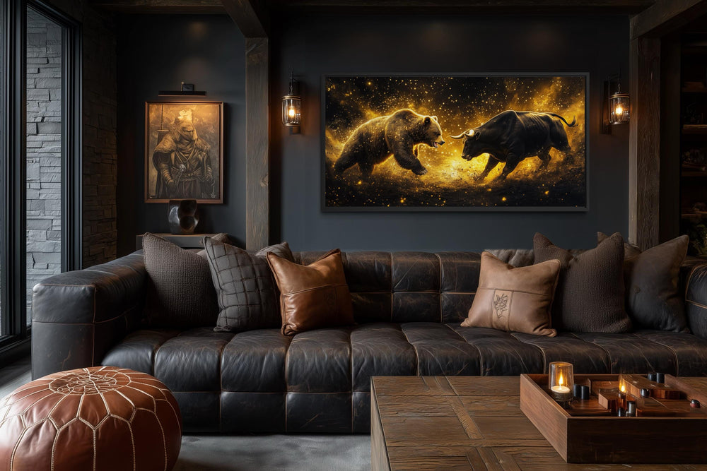 A dramatic canvas print of a bull and bear fighting in gold and black hangs in a dark, modern office.