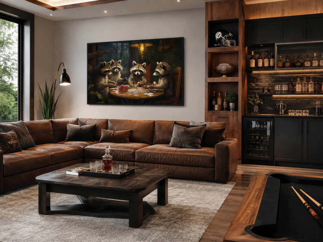 Framed canvas wall art of raccoons playing poker in a dark, cozy man cave above a leather sofa.