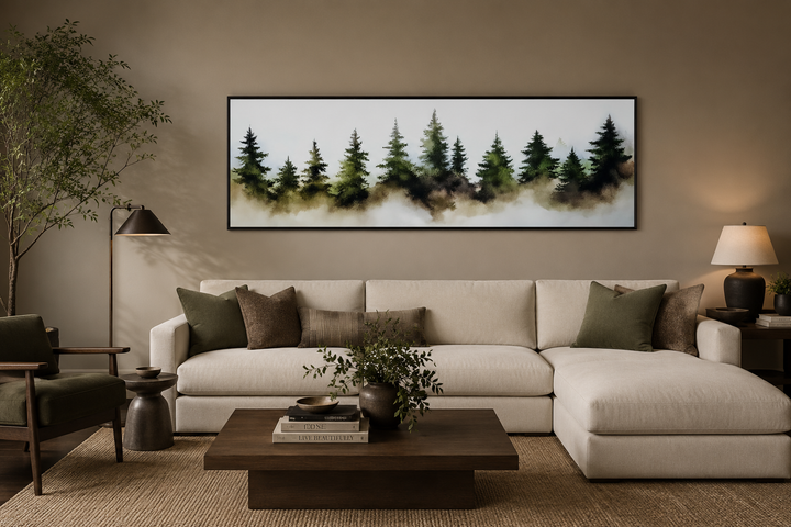 Foggy green pine trees forest horizontal wall art in a black frame above a beige sectional sofa.