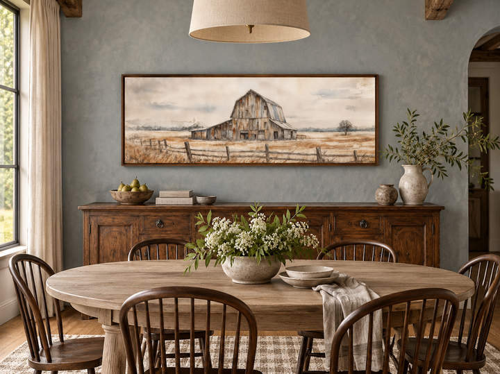 Rustic barn wall art in a long horizontal frame above a wooden sideboard in a farmhouse dining room.