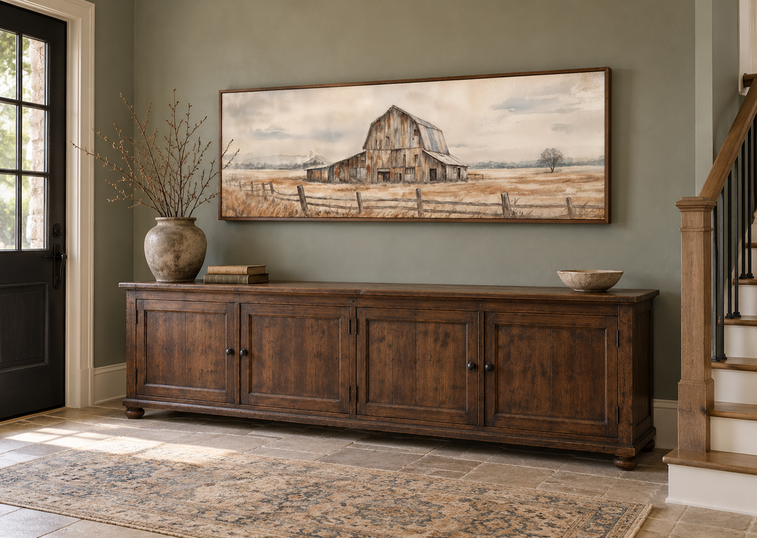 Rustic barn wall art in a long horizontal frame above a dark wood sideboard in a farmhouse entryway.