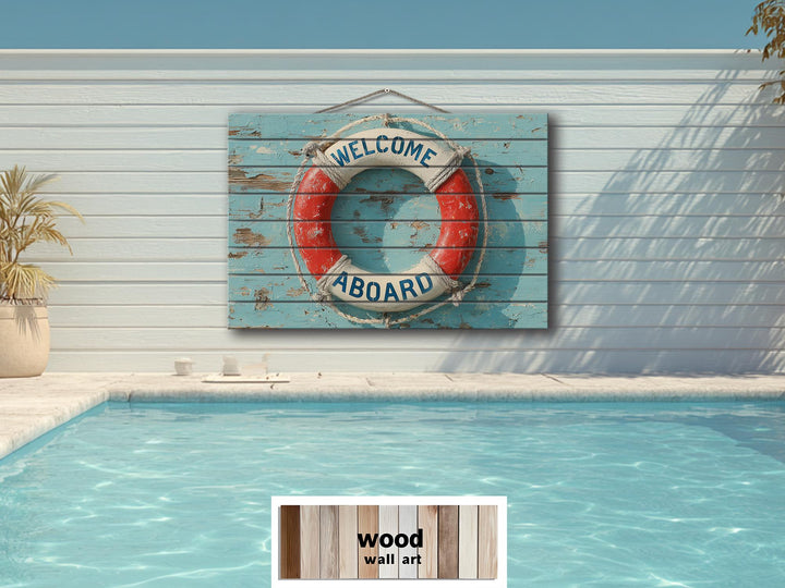 A distressed wood sign featuring a nautical lifebuoy with Welcome Aboard text hangs above a pool.