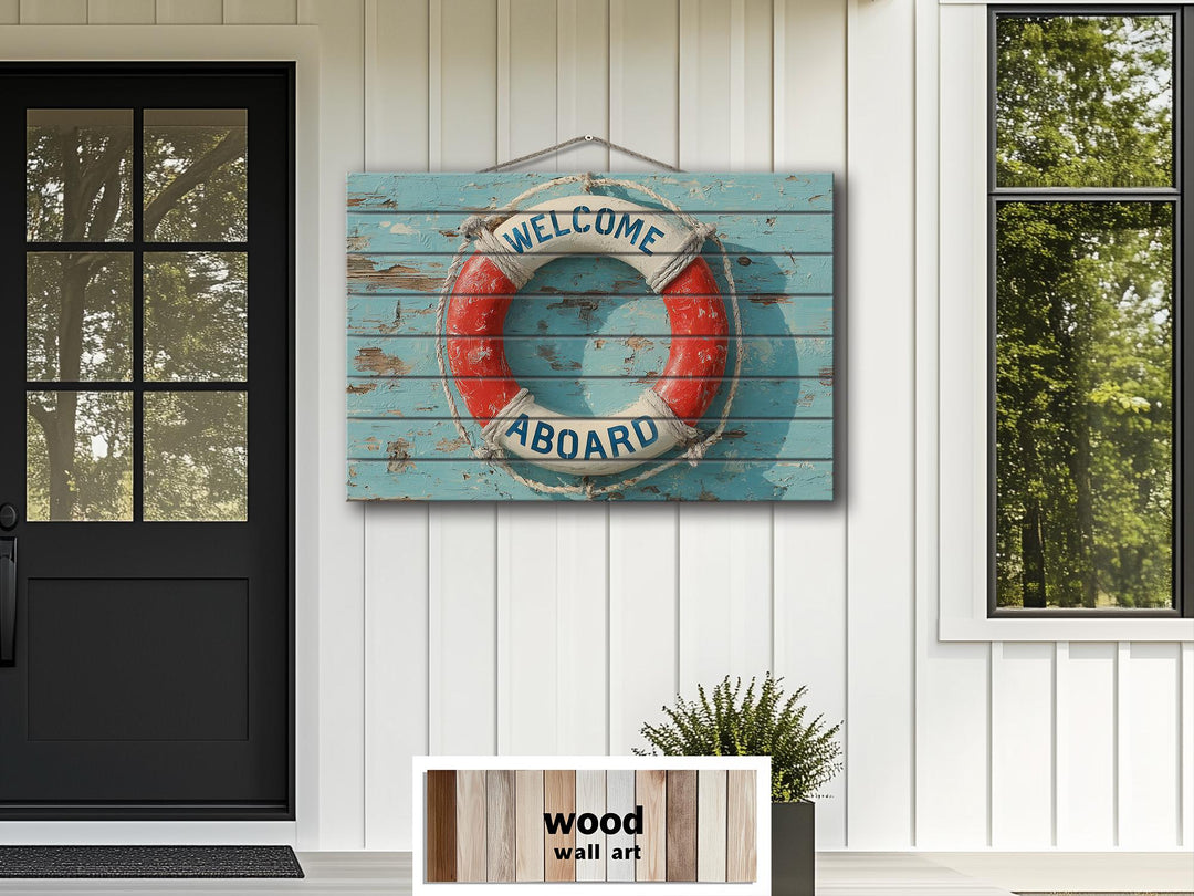 Nautical Welcome Aboard lifebuoy wood wall art sign hanging on a white paneled exterior wall.