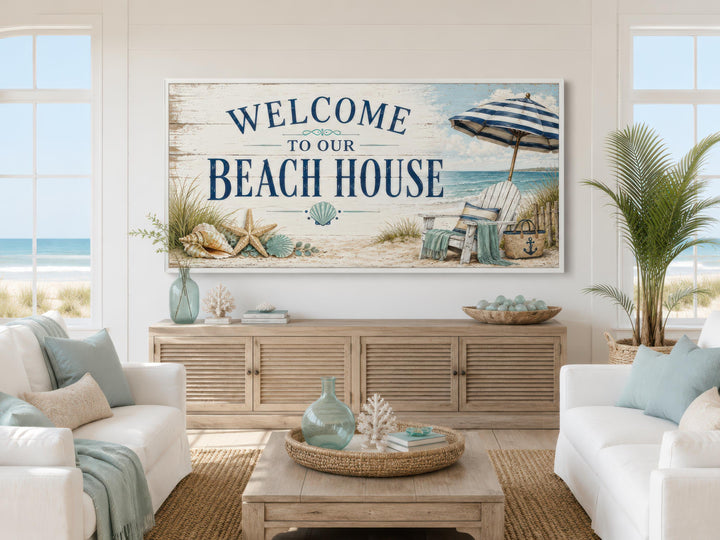 Welcome To Our Beach House rustic canvas print above a wooden console in a coastal living room.