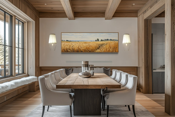 Long horizontal framed canvas wall art of a golden wheat field landscape in a rustic dining room.