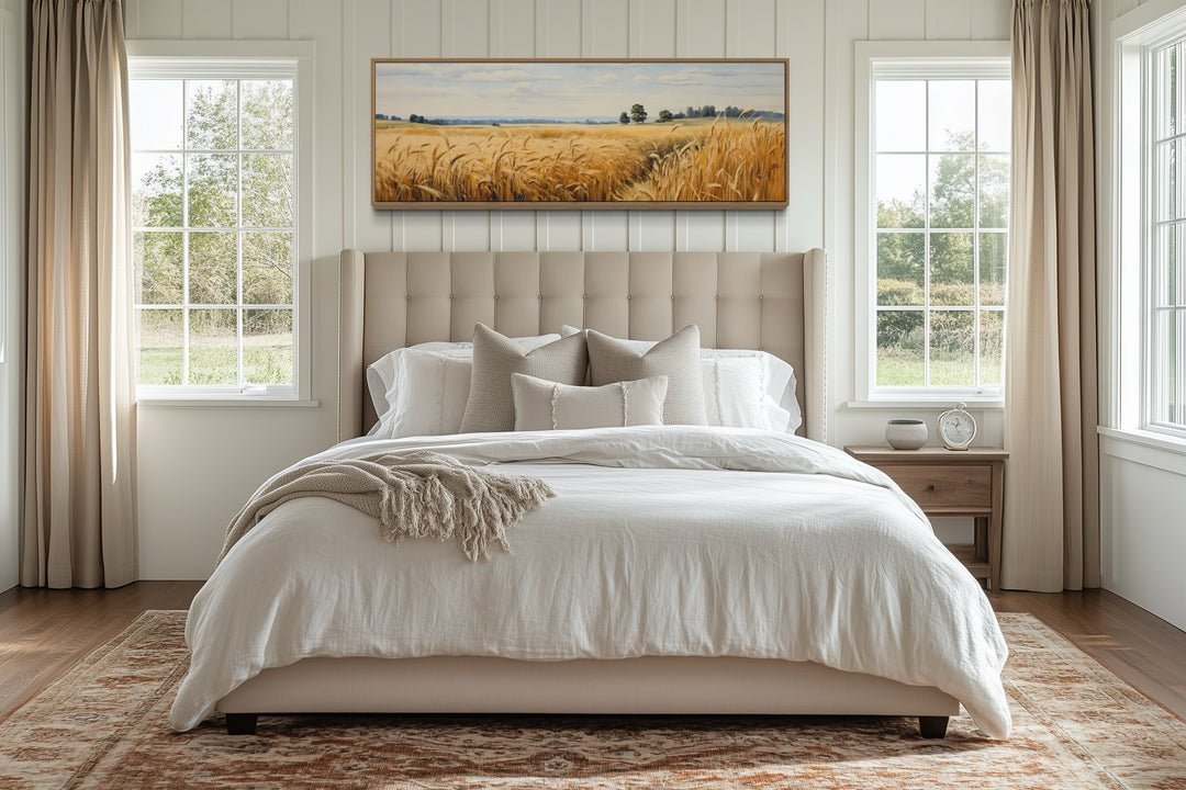 Wheat field farm landscape long horizontal framed canvas wall art above a bed in a farmhouse room.