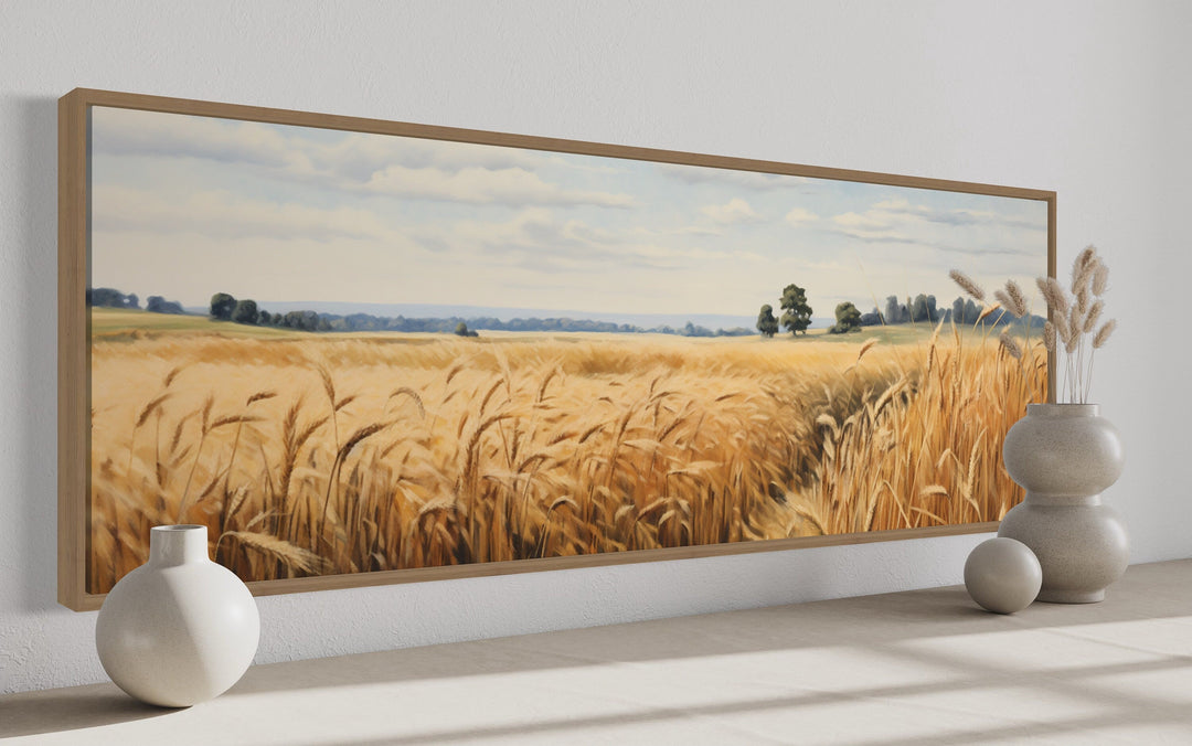 Long horizontal framed canvas wall art of a golden wheat field farm landscape in a wood frame.