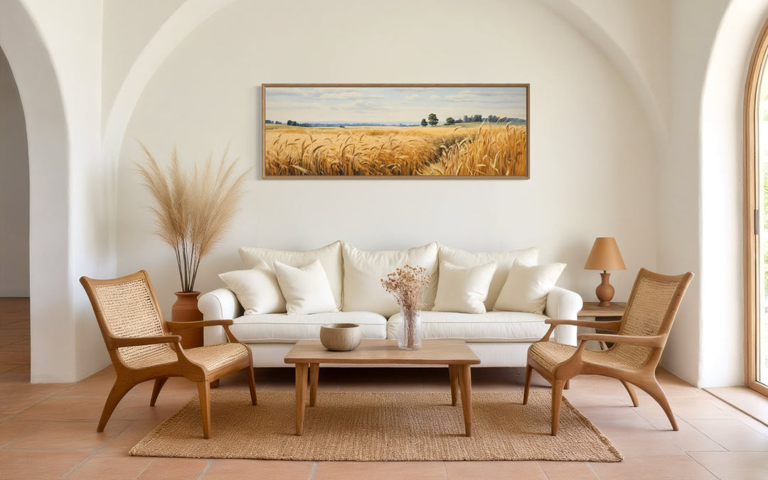 Long horizontal framed canvas wall art of a golden wheat field landscape in a farmhouse living room.