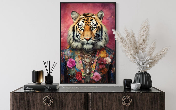 Framed canvas wall art of a tiger in a floral pink suit above a dark wood dresser.