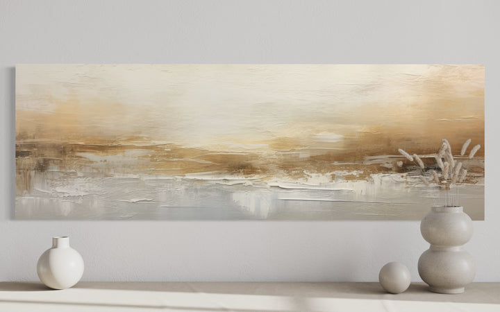 White and gold abstract long narrow wall art displayed over a console with decorative vases.