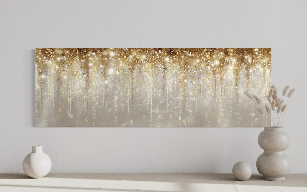 Long horizontal canvas wall art featuring abstract gold rain on a soft white and beige background.