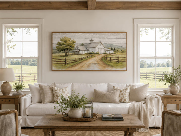 White barn wall art in a rustic farmhouse living room above a white sofa with neutral pillows.