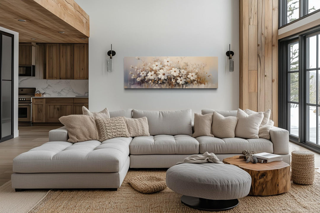 Panoramic white and beige wildflower canvas wall art hanging above a neutral sectional sofa.