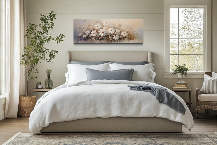 White beige neutral wildflowers farmhouse framed canvas wall art hanging above a bed.