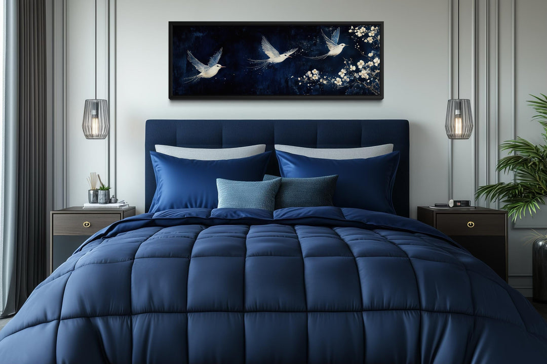 Long narrow canvas wall art featuring white birds and blossoms on a navy blue background.