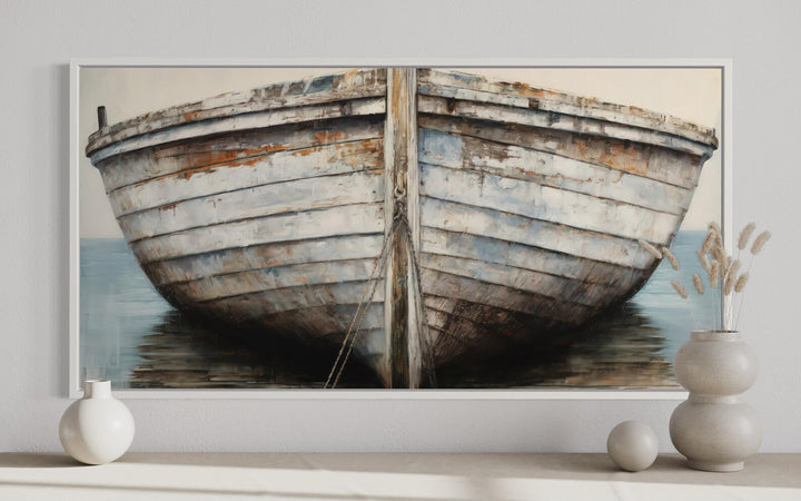Framed canvas wall art featuring a close-up painting of a rustic, weathered white and brown boat.