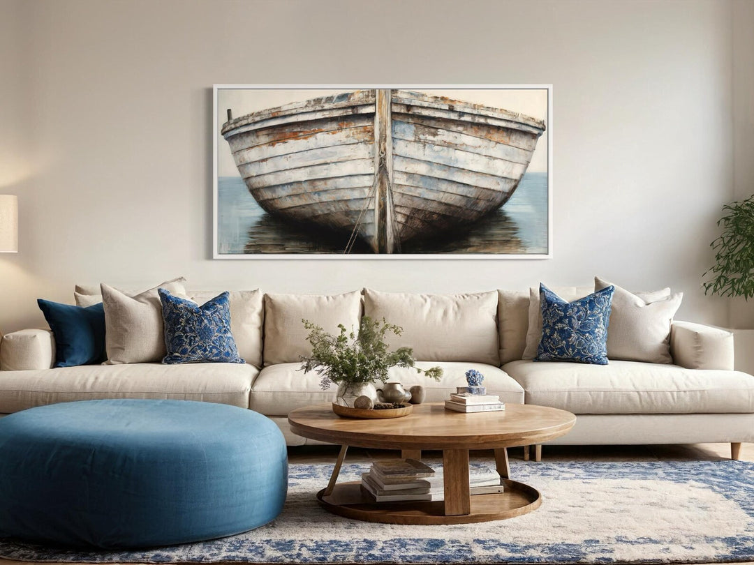 White and brown rustic old boat close-up framed canvas wall art hanging above a neutral sofa.