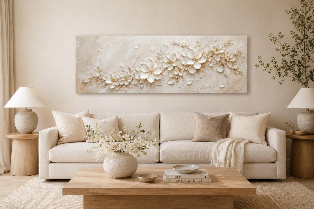 Long horizontal white floral canvas wall art above a cream sofa in a neutral living room.