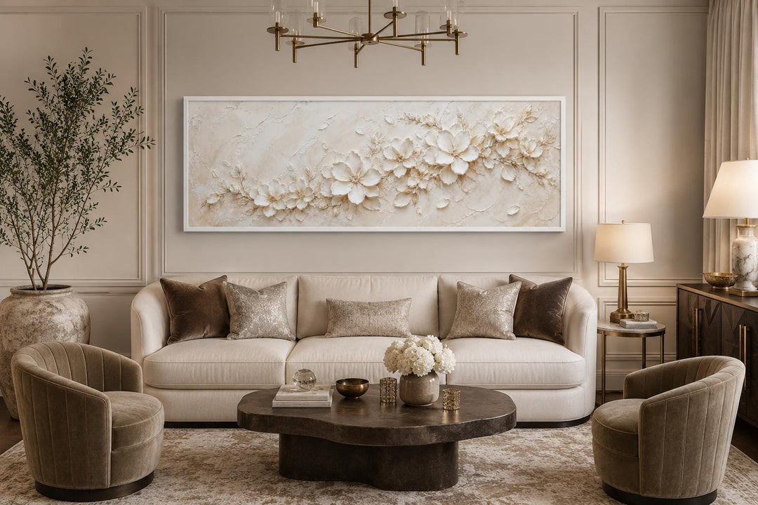 Long horizontal white floral canvas wall art with textured blossoms above a neutral sofa.