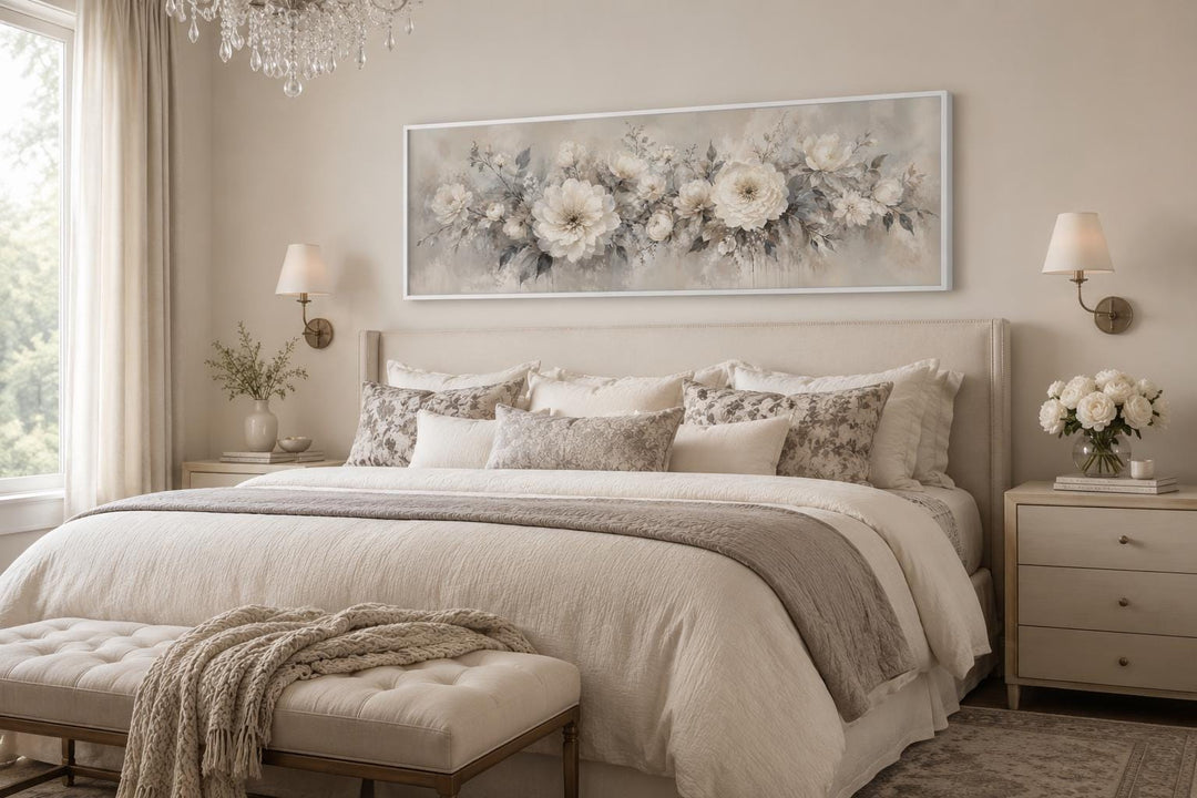 Long horizontal canvas print of white peonies in a neutral bedroom above a beige headboard.