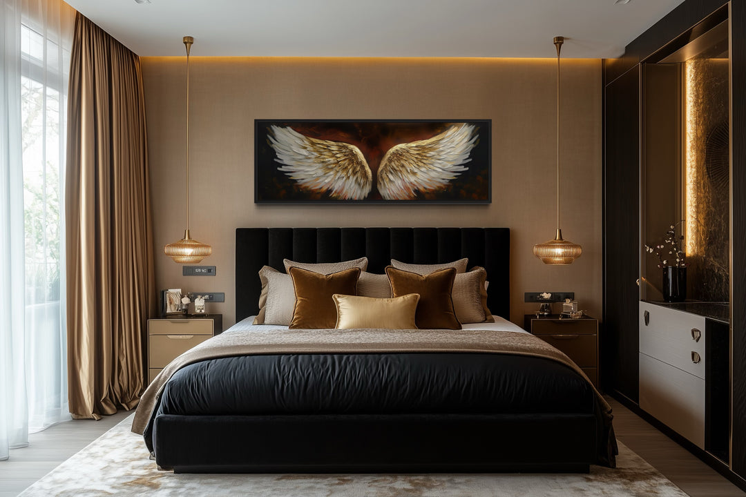 Horizontal framed canvas of white and gold angel wings on a brown background above a black bed.