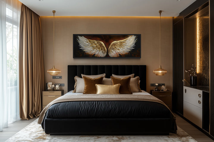 Horizontal framed canvas of white and gold angel wings on a brown background above a black bed.