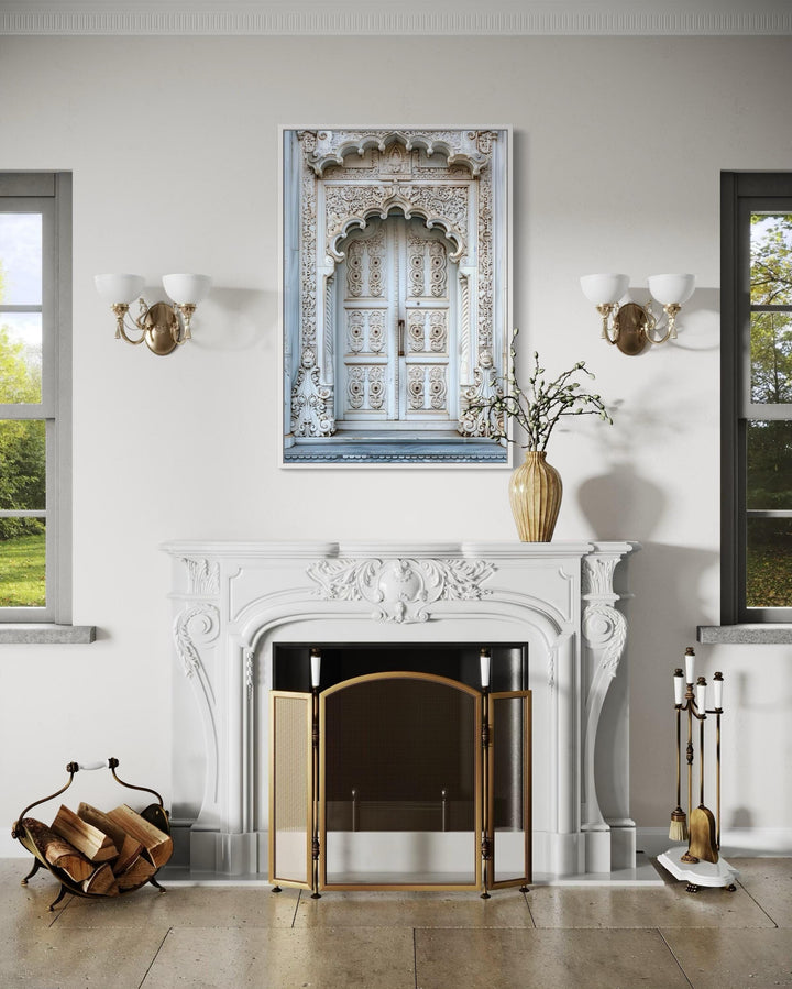 White and grey Indian door framed canvas wall art hanging above a white fireplace mantel.