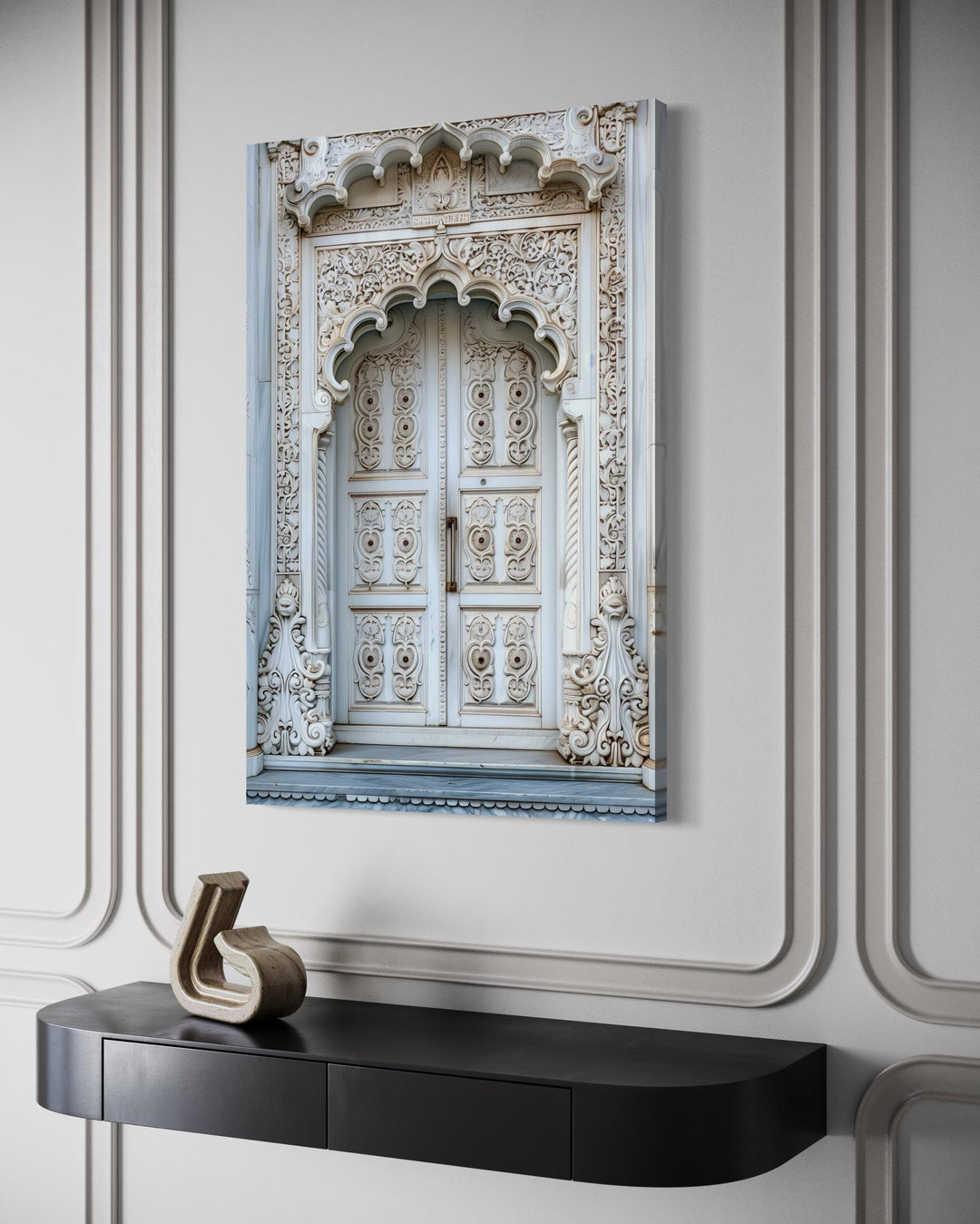 White and grey Indian door framed canvas wall art hanging above a black console table.