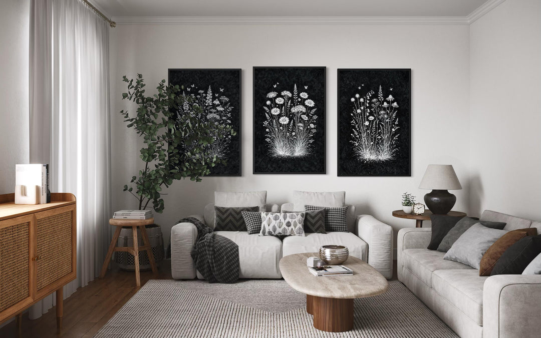 Set of three black and white wildflower canvas prints displayed in a modern rustic living room.