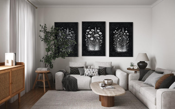 Set of three black and white wildflower canvas prints displayed in a modern rustic living room.