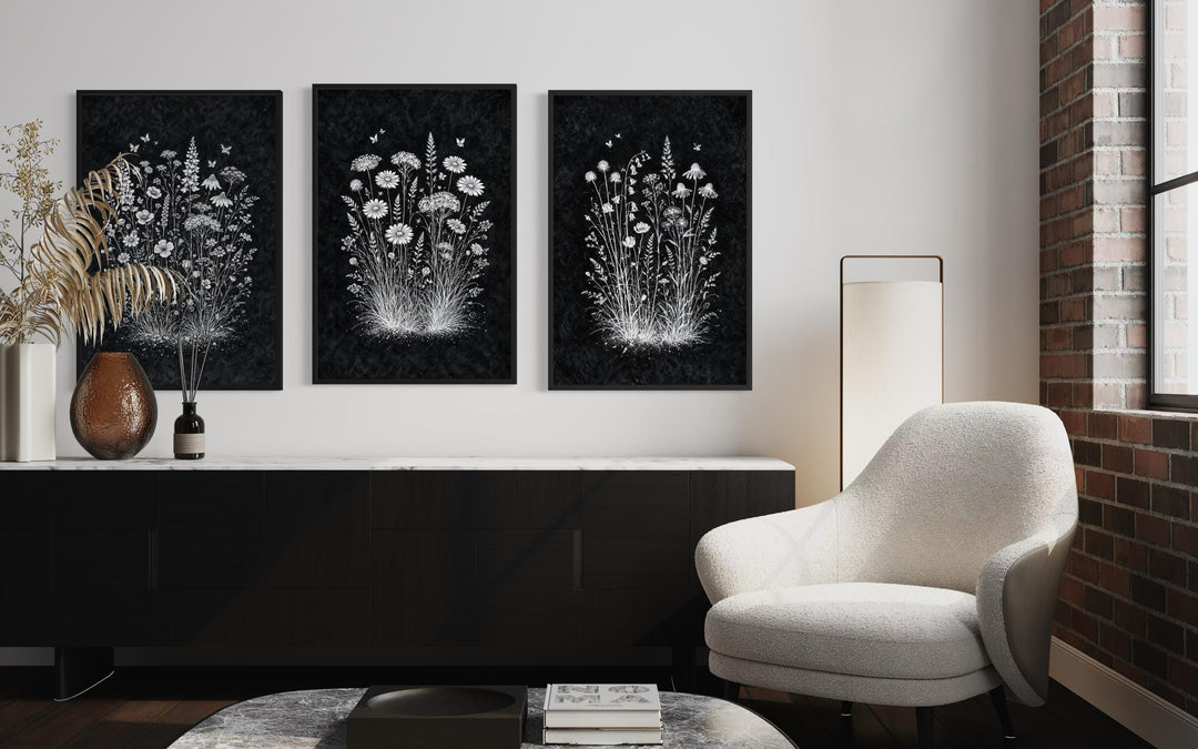 Set of three black and white wildflower canvas prints displayed in a modern rustic living room.