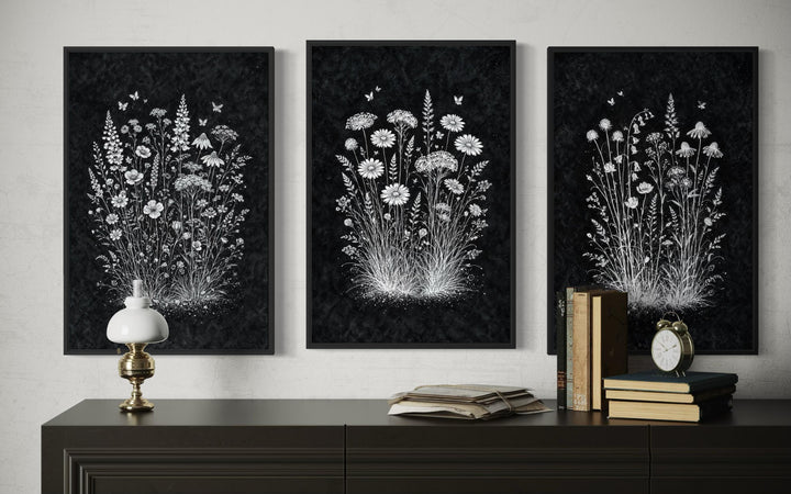 Three framed black and white wildflower botanical prints displayed above a dark wooden dresser.