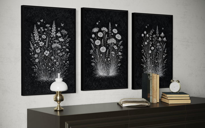 Three framed black and white wildflower canvas prints displayed above a dark wood dresser.