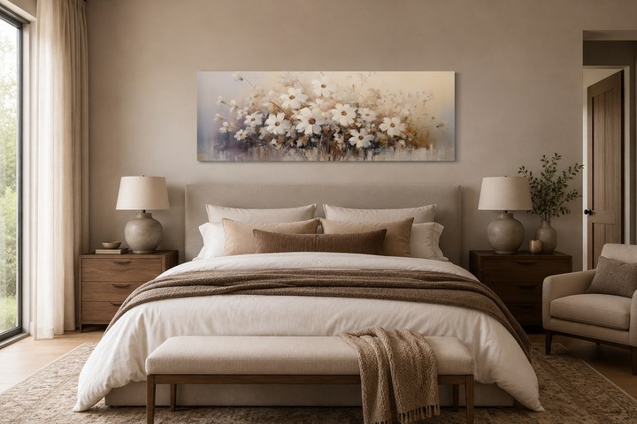 White and beige horizontal wildflower canvas wall art hanging above a bed in a neutral bedroom.