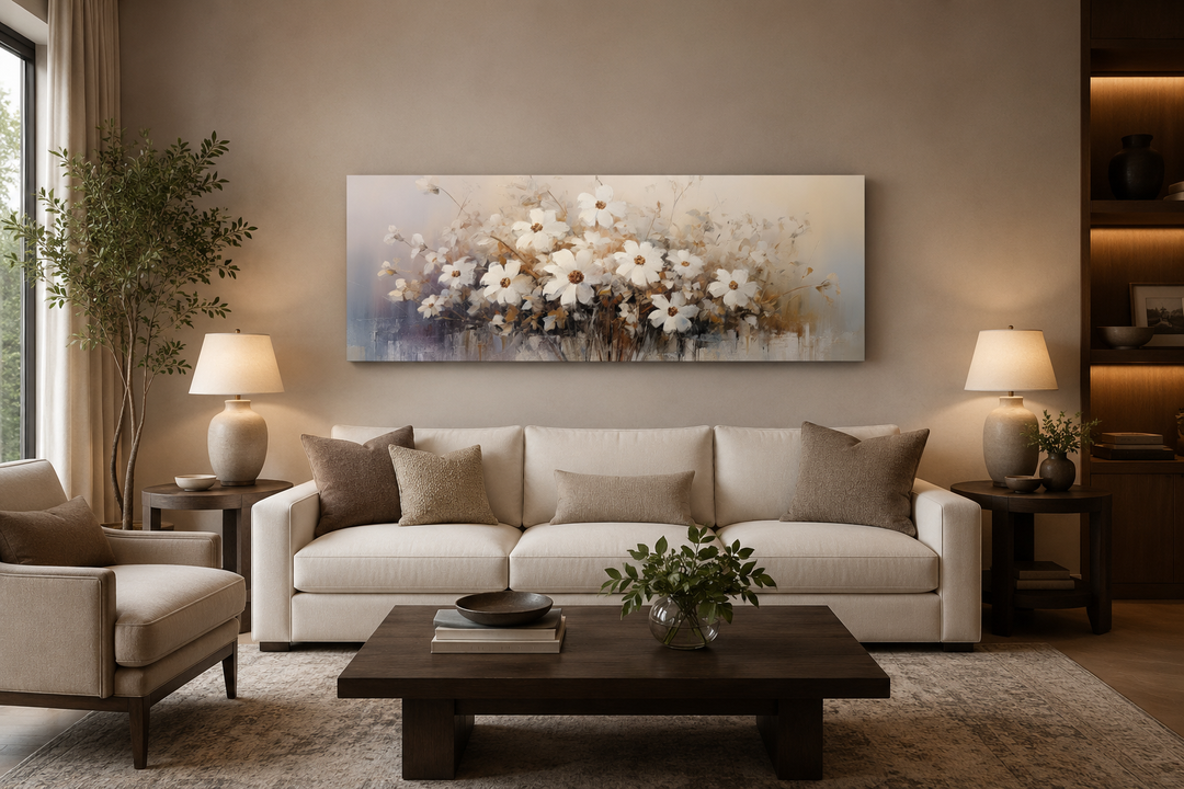 Horizontal framed canvas wall art of white wildflowers in a neutral living room above a sofa.