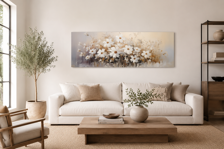 Panoramic white and beige wildflower canvas wall art hanging above a neutral sofa in a living room.