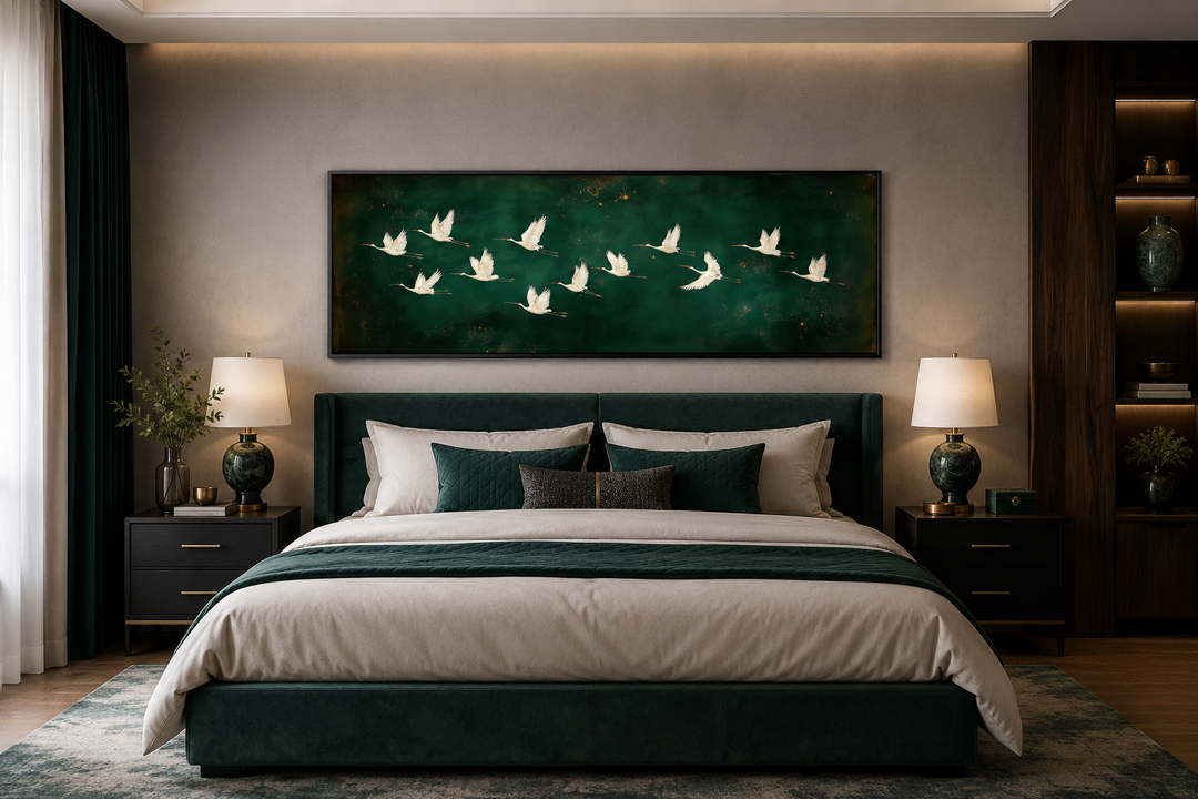 White birds flying across a long horizontal emerald green canvas wall art above a bed.