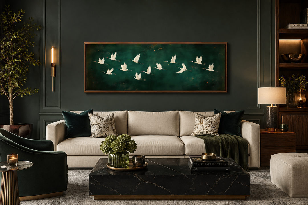 White birds flying across a long horizontal emerald green canvas wall art above a beige sofa.