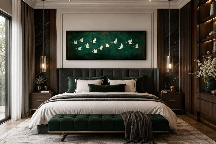 White birds flying on a long horizontal emerald green canvas wall art above a bed in a bedroom.