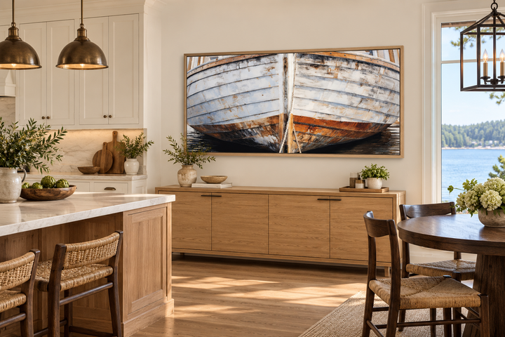 Old wooden boat canvas art in a rustic frame hanging above a wooden sideboard in a coastal kitchen.