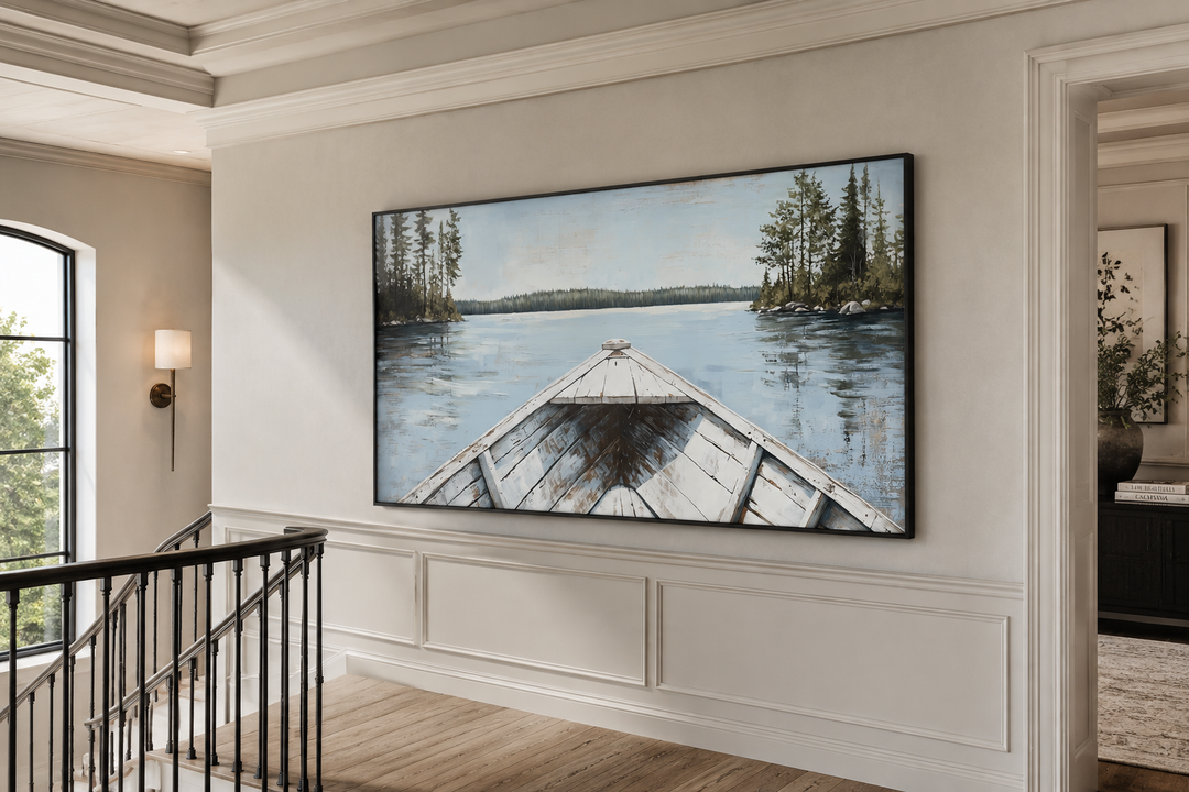 Large framed canvas art of a white canoe on a calm blue lake with evergreen trees in a hallway.