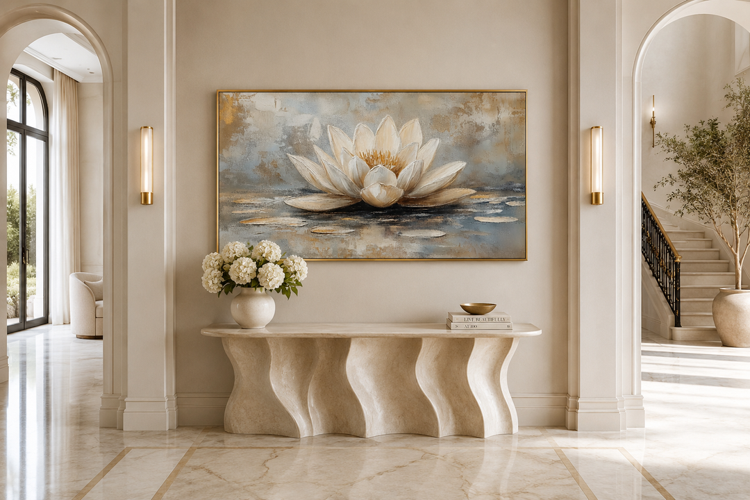 Framed canvas wall art of a white and gold lotus flower above a wavy console table in a zen room.